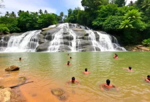 Lakkam Waterfalls cascading down rocky cliffs into a natural pool.