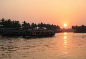 Traditional houseboat on Alappuzha backwaters during a cool winter sunset in Kerala